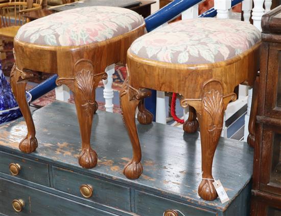 A pair of oval walnut stools W.56cm